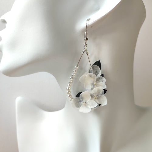 Image de boucles d'oreilles élégantes en perles et fleurs blanches stabilisées, faites à la main, parfaites pour les mariages et occasions spéciales