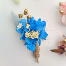 Charger l&#39;image dans la galerie, Boutonnière florale bleue avec des fleurs préservées et des accents dorés.
